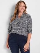 Black and white knit top with an abstract geometric pattern, V-neck, and 3/4 rolled sleeves.