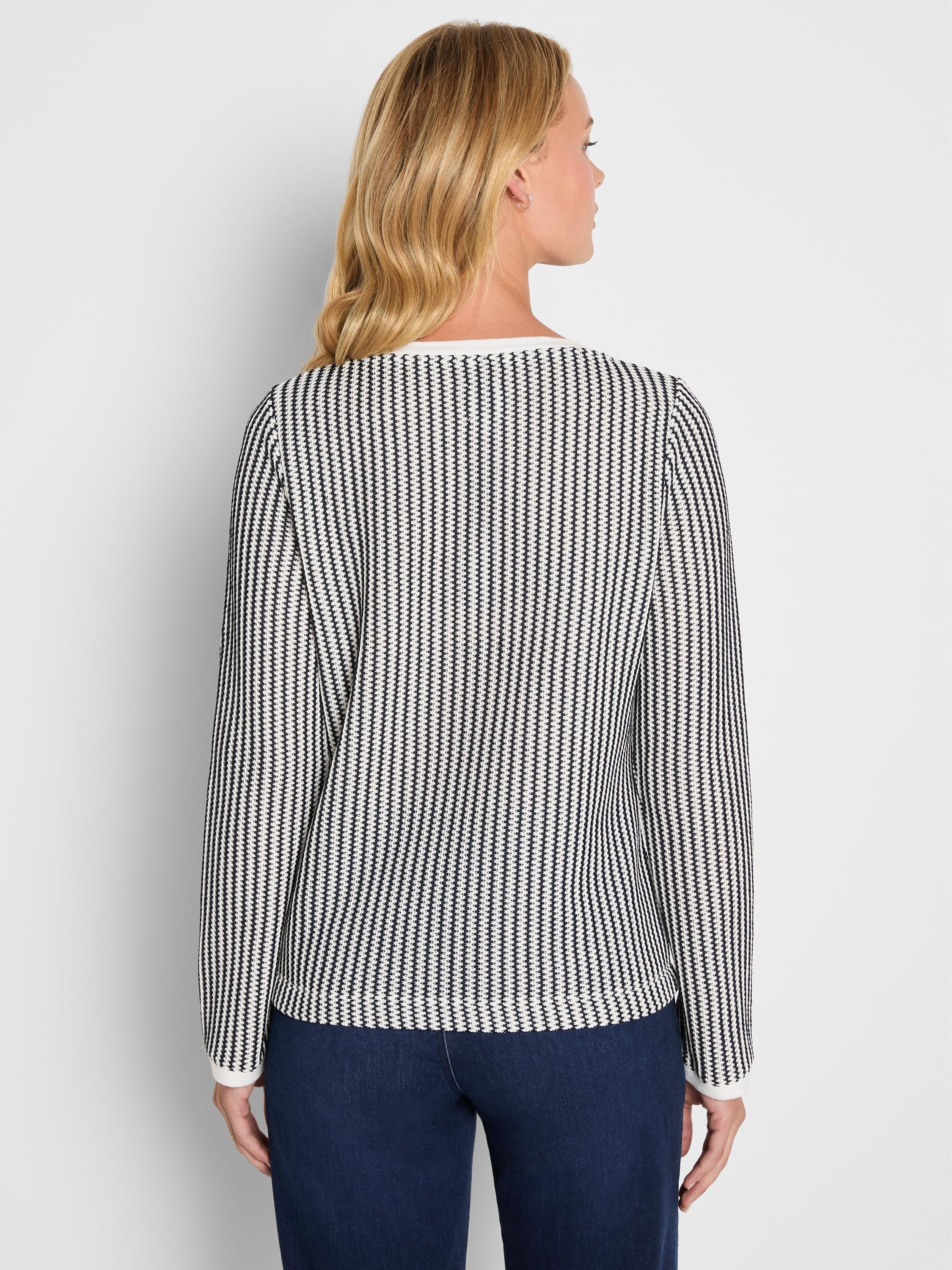 A fitted black and white vertical patterned long sleeve knit top features solid white trim at the neckline and cuffs.
