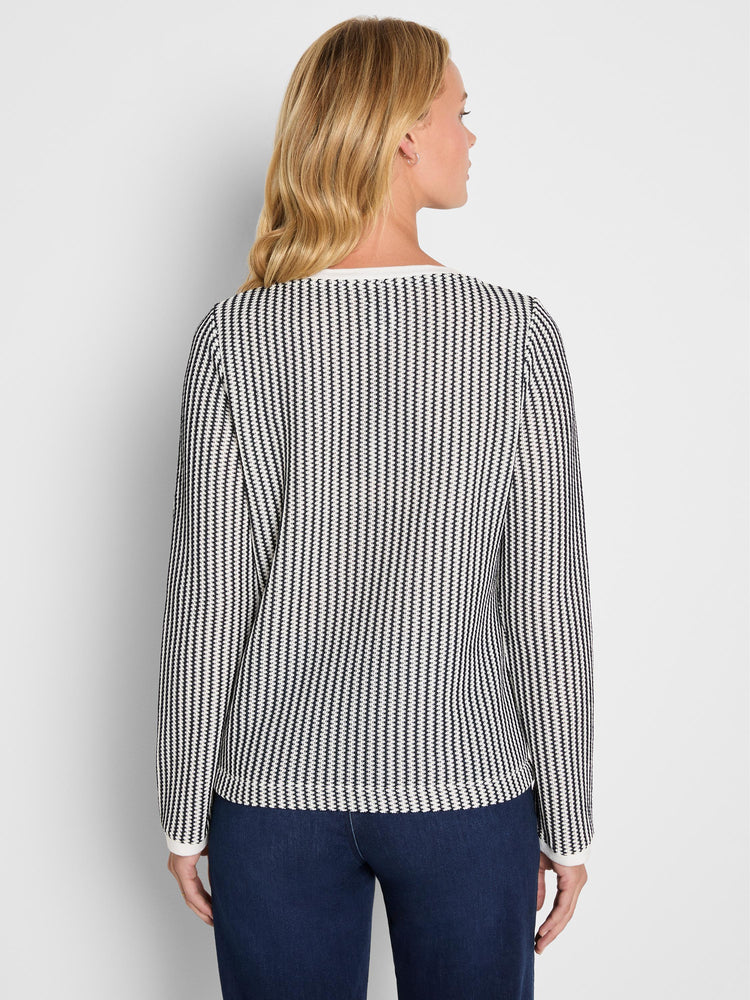 A fitted black and white vertical patterned long sleeve knit top features solid white trim at the neckline and cuffs.