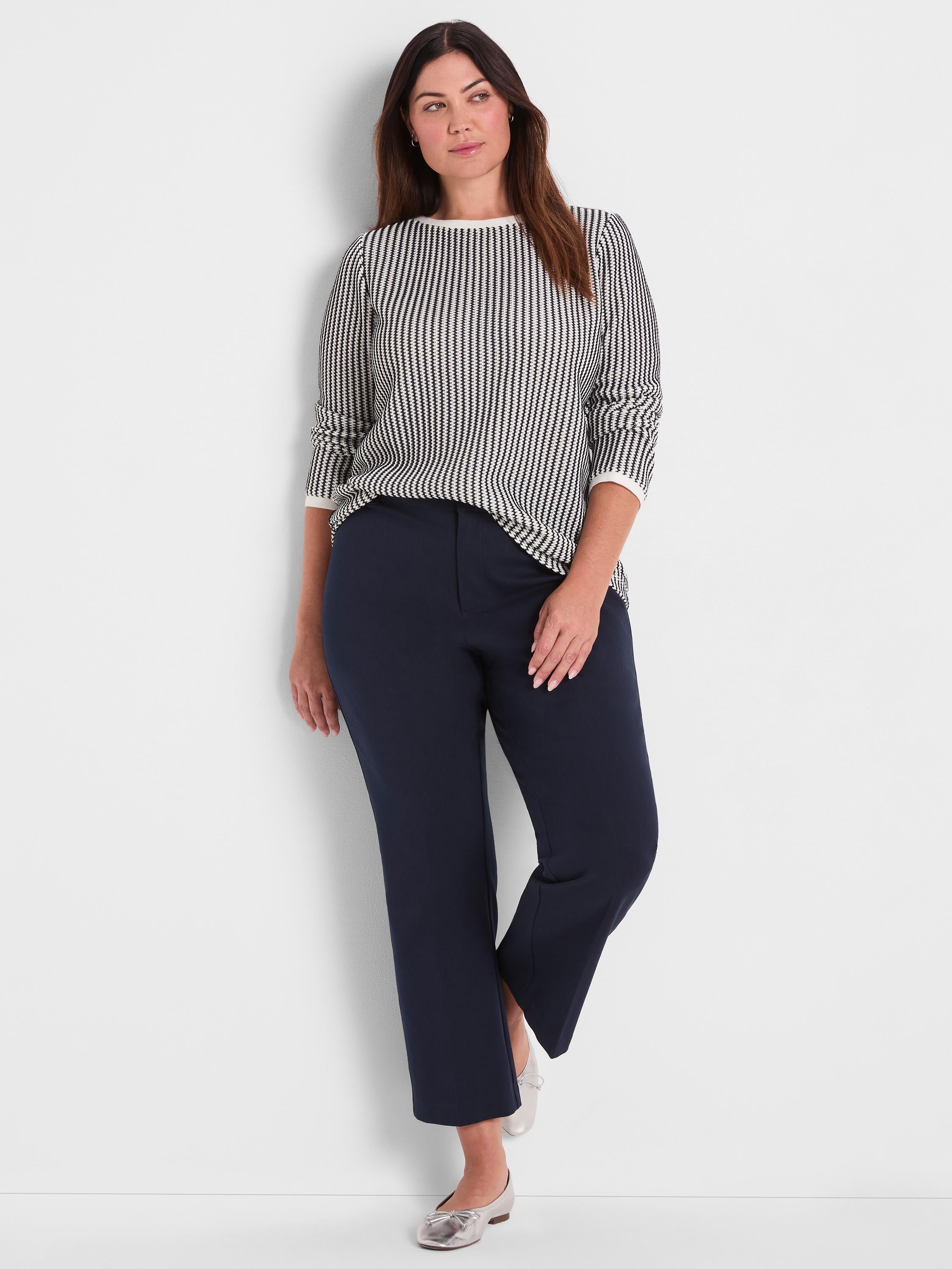 Relaxed fit black and white patterned knit pullover featuring white trim paired with navy cropped wide-leg trousers.