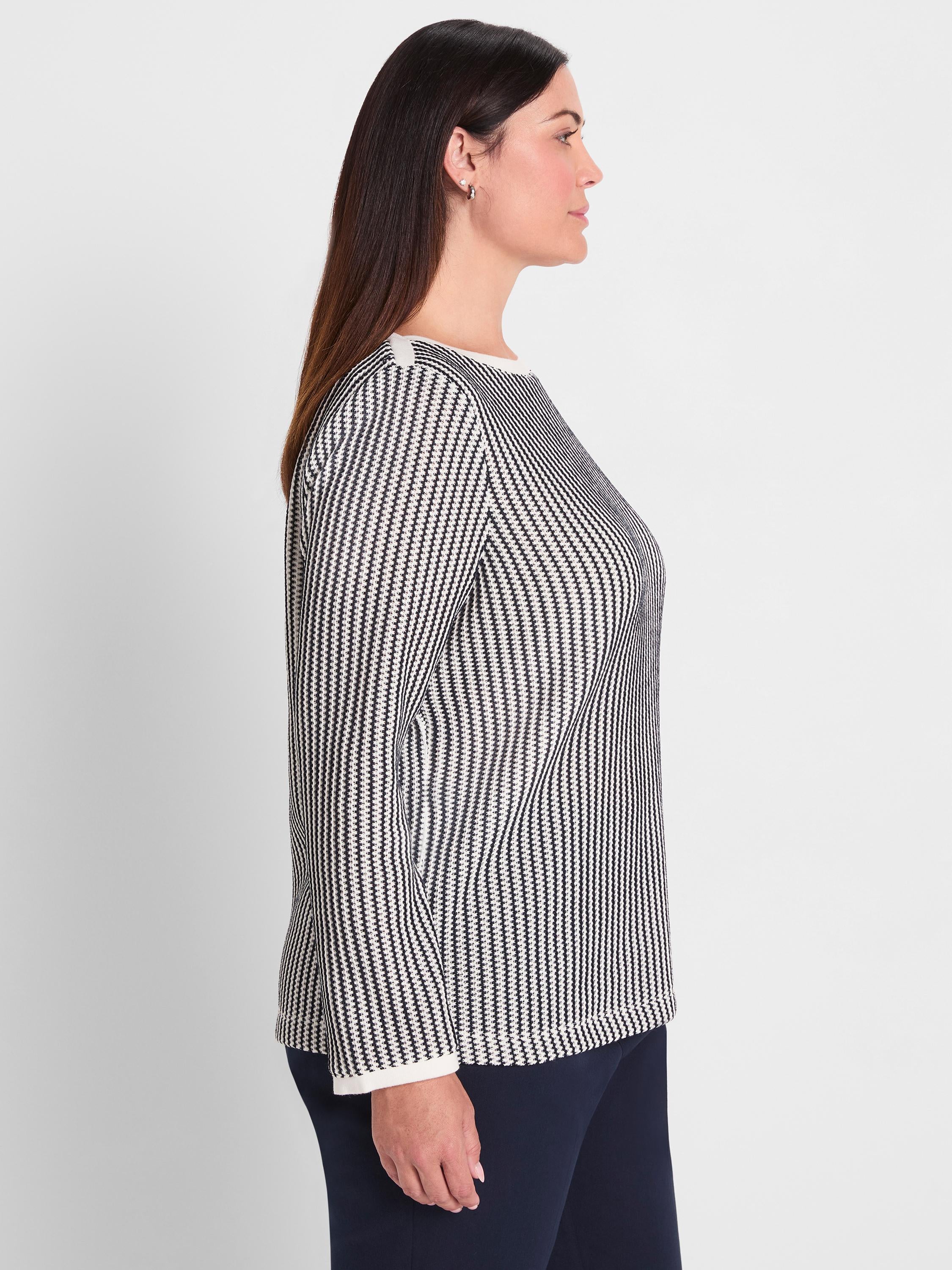 A black and white patterned knit top featuring a classic fit, long sleeves, and contrast white trim at the neck and cuffs.