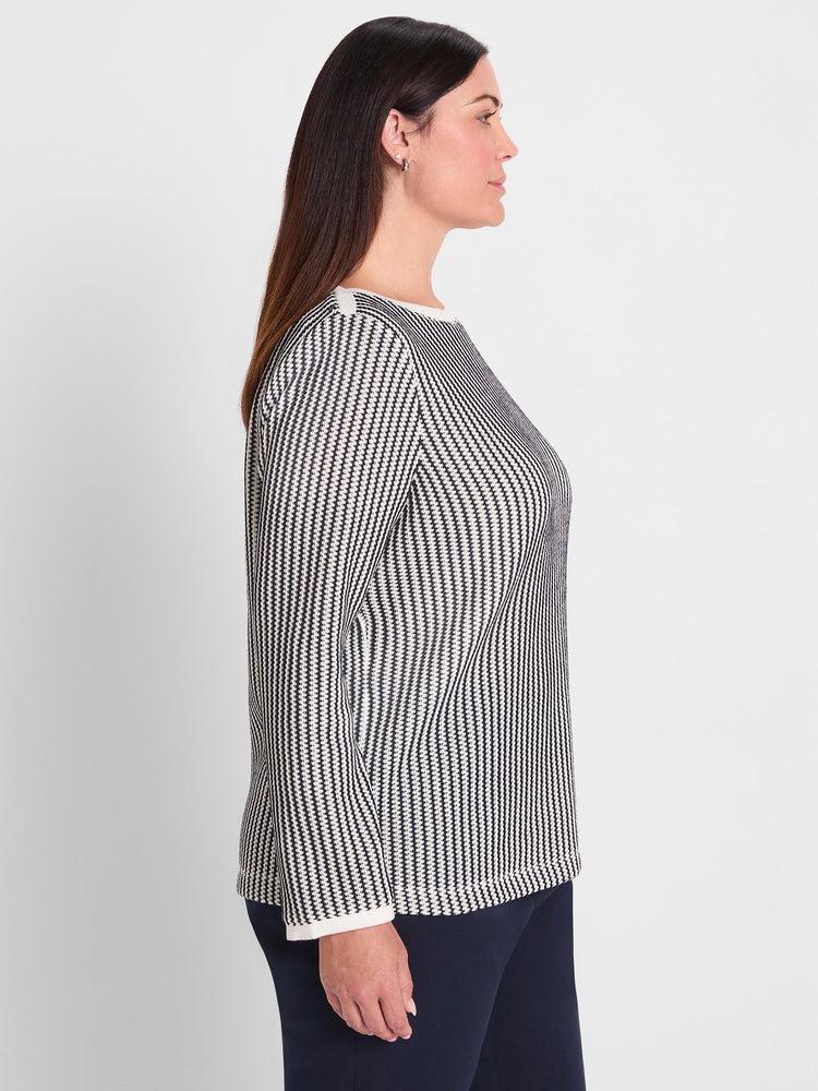 A black and white patterned knit top featuring a classic fit, long sleeves, and contrast white trim at the neck and cuffs.
