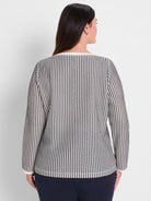 Black and white patterned knit top with long sleeves features a standard fit and contrasting white trim detail.