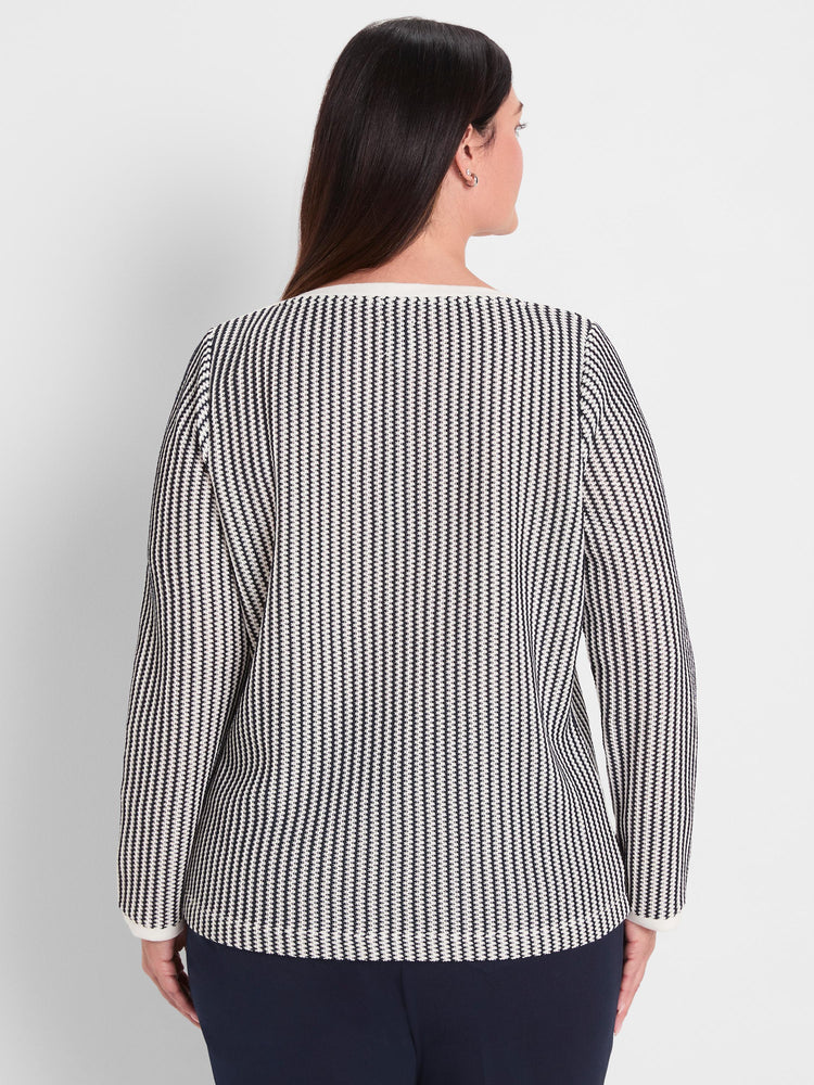 Black and white patterned knit top with long sleeves features a standard fit and contrasting white trim detail.