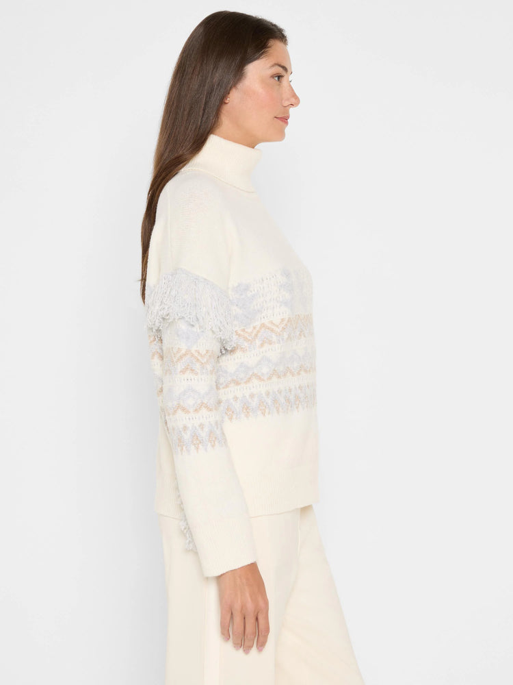 Cream turtleneck sweater with light grey fringe on shoulders and a grey and tan geometric pattern.