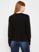 Black waffle tuck knit cardigan. Back view with long sleeves, ribbed cuffs & hem.