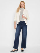 Off-white cardigan with visible waffle texture and tan button-front closure.