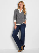 Black and off-white geometric jacquard sweater with a cream polo collar, cuffs, and hem.