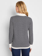 Jacquard sweater in dark blue and cream zigzag pattern. Cream collar, cuffs, and hem.