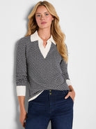 Two-tone black & white jacquard sweater with a geometric pattern, white V-neck collar, and ribbed cuffs.