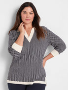 Two-tone navy and cream sweater with a zig-zag pattern. Features a V-neck, solid cream collar, cuffs, and hem.