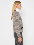 Tan, off-white, and dark brown grid pattern sweater cardigan with black trim.