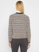 Cardigan with a grid pattern in beige, dark brown, and white, featuring silver threads. Rounded neckline with black trim.