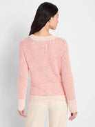 Heathered light pink waffle-knit sweater with off-white ribbed neckline, cuffs, and hem, worn from behind.