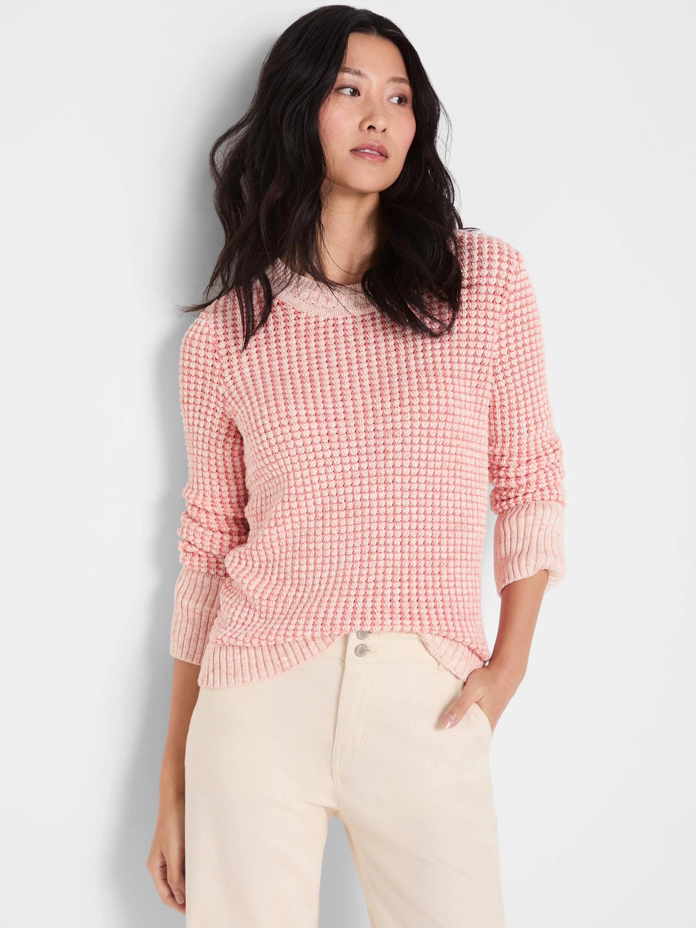 Pink textured knit sweater with a color spray effect, round neck, and long sleeves.