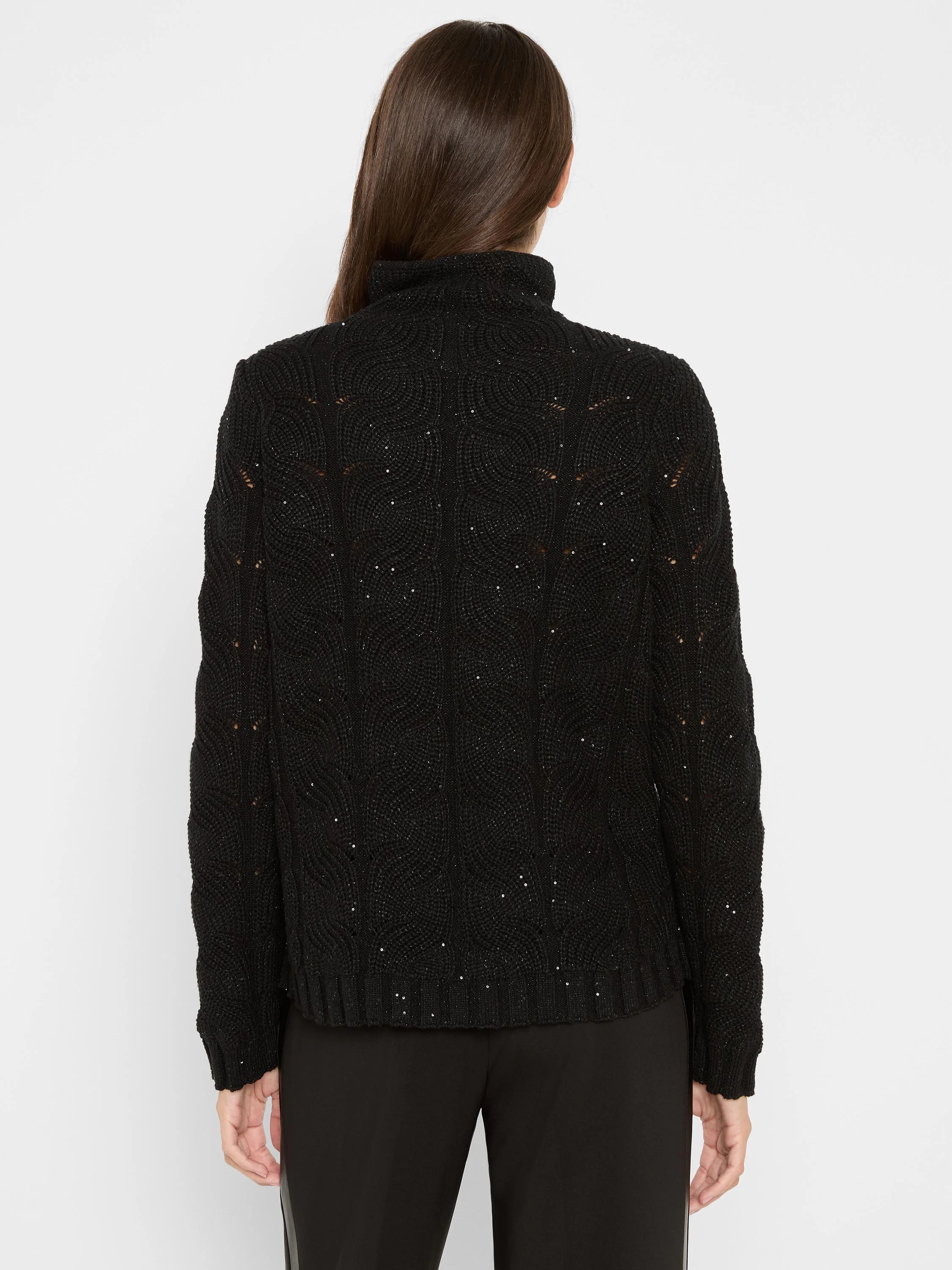 Black cable knit turtleneck sweater with subtle sparkles and openwork patterns, viewed from the back.