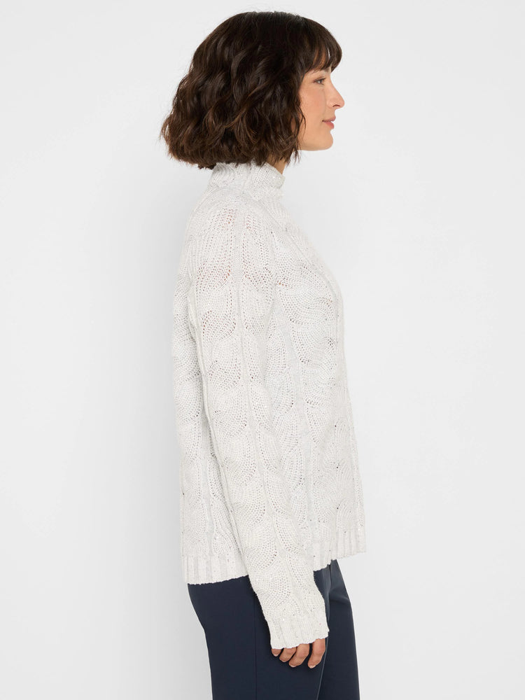 Off-white cable knit turtleneck sweater with subtle sparkle.