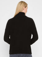 Black waffle tuck knit sweater on model's back, featuring a mock neck collar and ribbed texture.