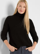 Black waffle knit turtleneck sweater, relaxed fit.