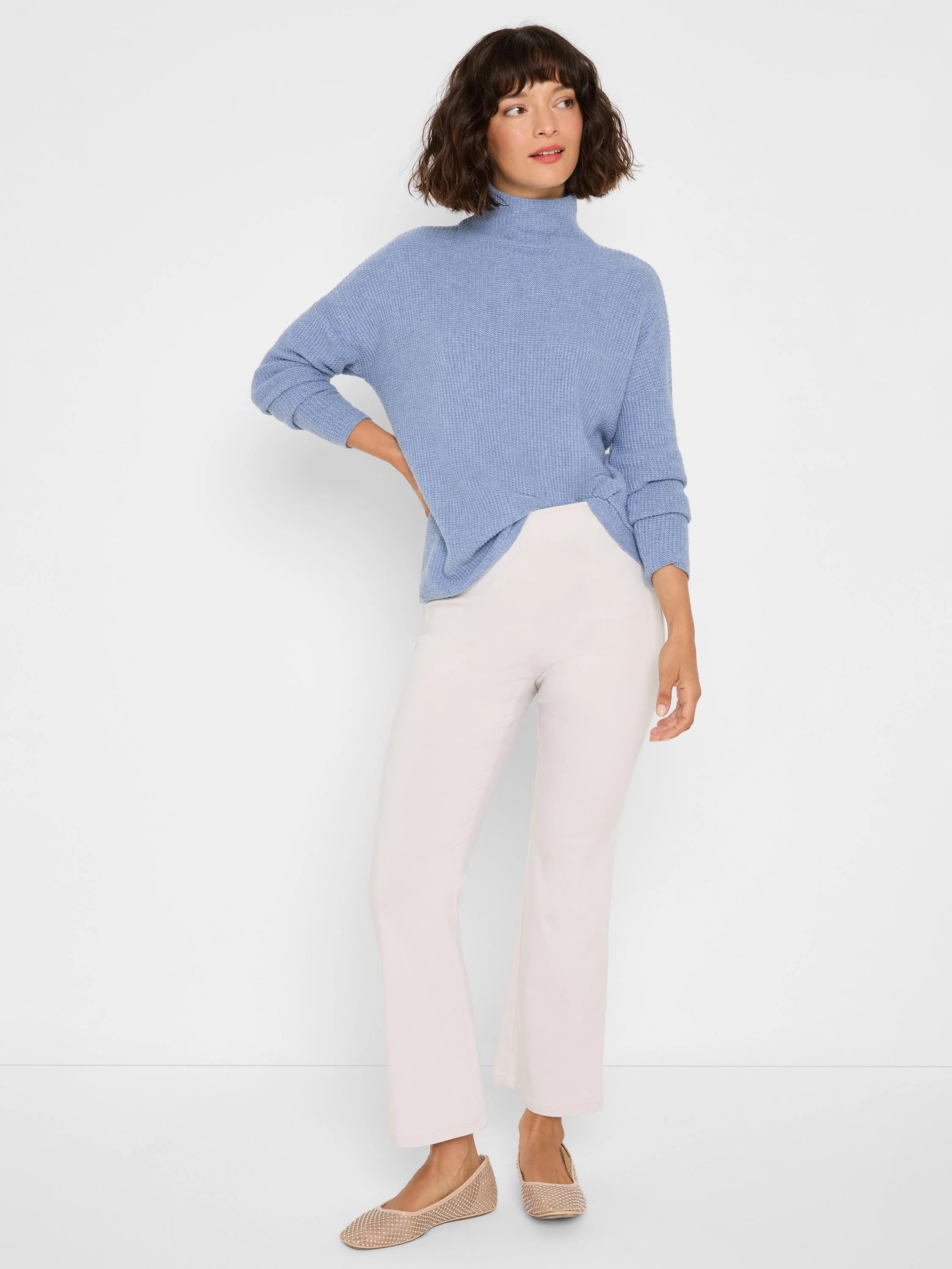 Pale blue waffle knit turtleneck sweater with a tucked hem.