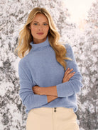 Light blue waffle tuck knit sweater with a mock neck and relaxed fit, worn by a model.