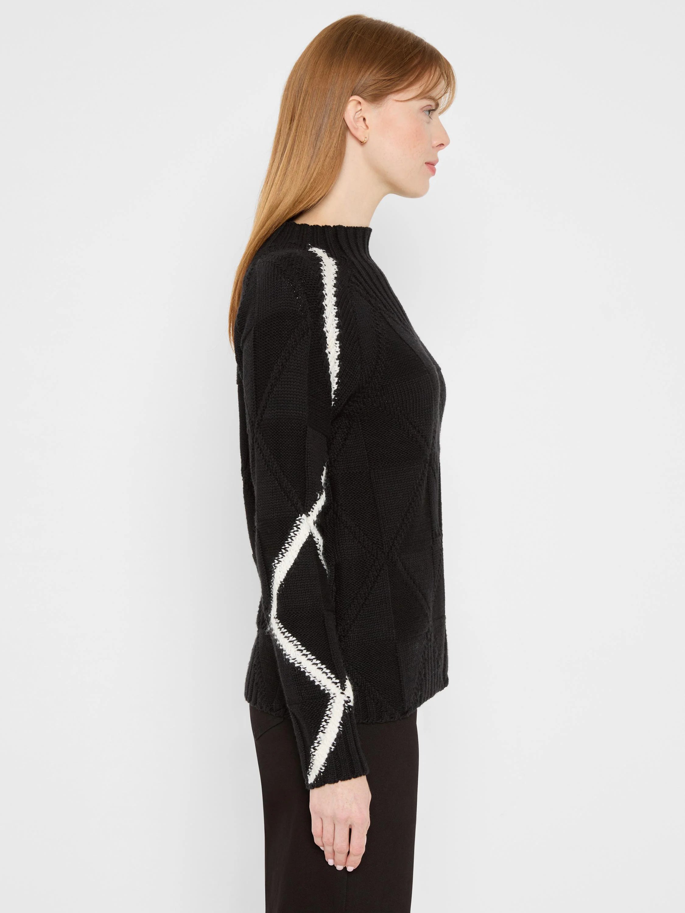 Black mock neck sweater with white zigzag diamond pattern on sleeves and sides.