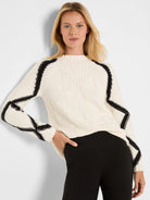 Cream sweater with knitted diamond pattern, black zigzag stripes on shoulders & sleeves, and a mock neck.