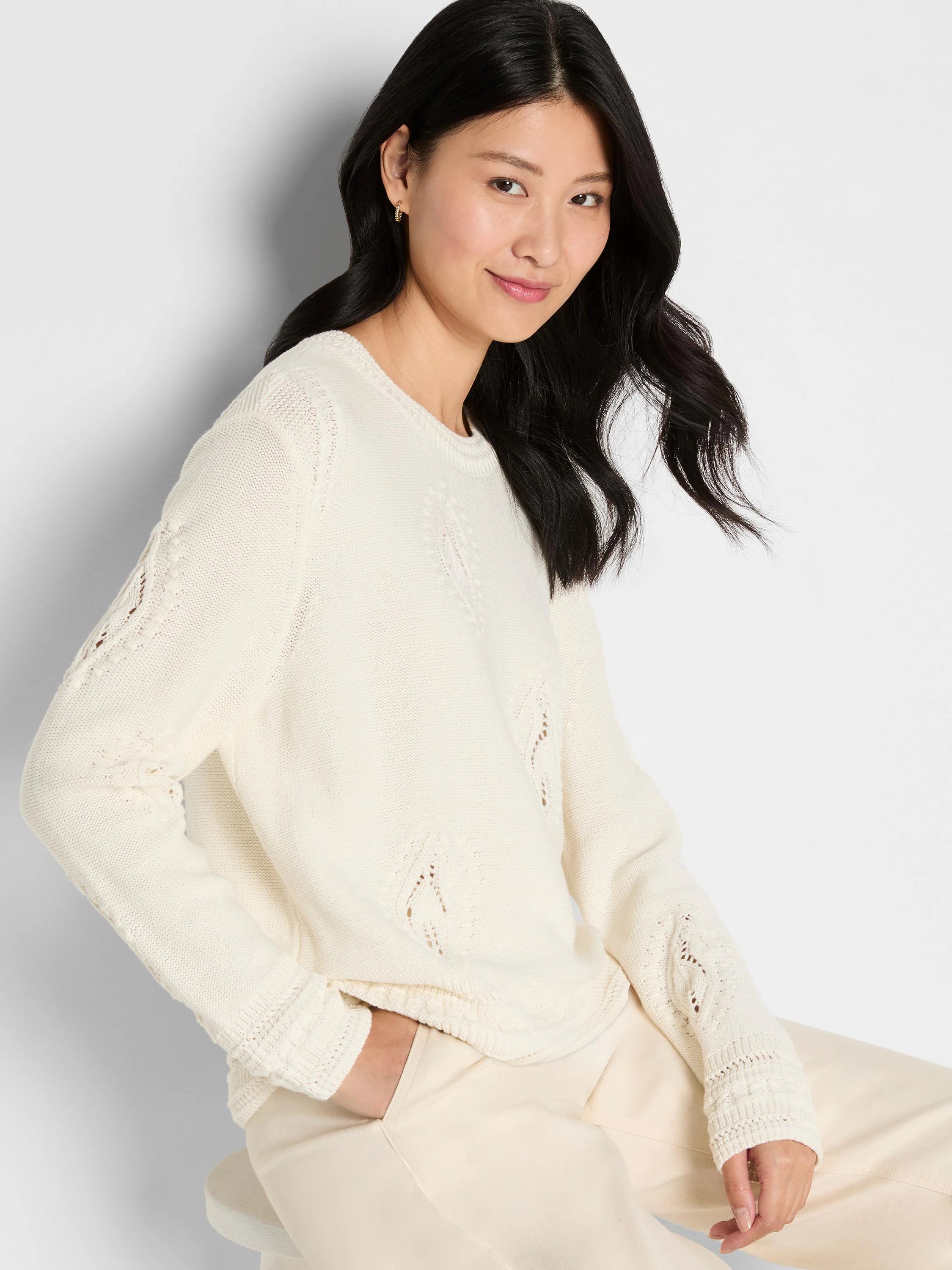 Ivory knit sweater with lace-knit paisley dot patterns on body and sleeves, ribbed cuffs.