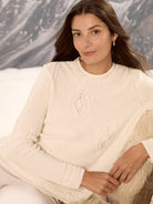 Cream knit sweater with raised paisley & dot patterns on chest & sleeves, and a crew neck.