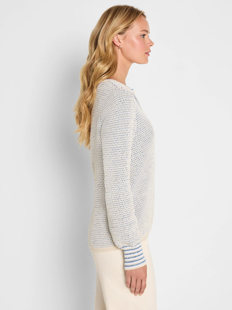 Cream & blue tuck texture sweater on model, side view. Features split neck and striped ribbed cuffs.