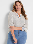 Cream open-knit sweater with blue texture, a split V-neck, and blue-striped trim on the neckline and cuffs.