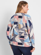 Back of sweater with abstract geometric pattern in navy, light blue, pink, beige, and off-white.