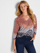 A relaxed fit V-neck knit sweater with 3/4 sleeves features a multicolored ombre leopard spot print pattern.