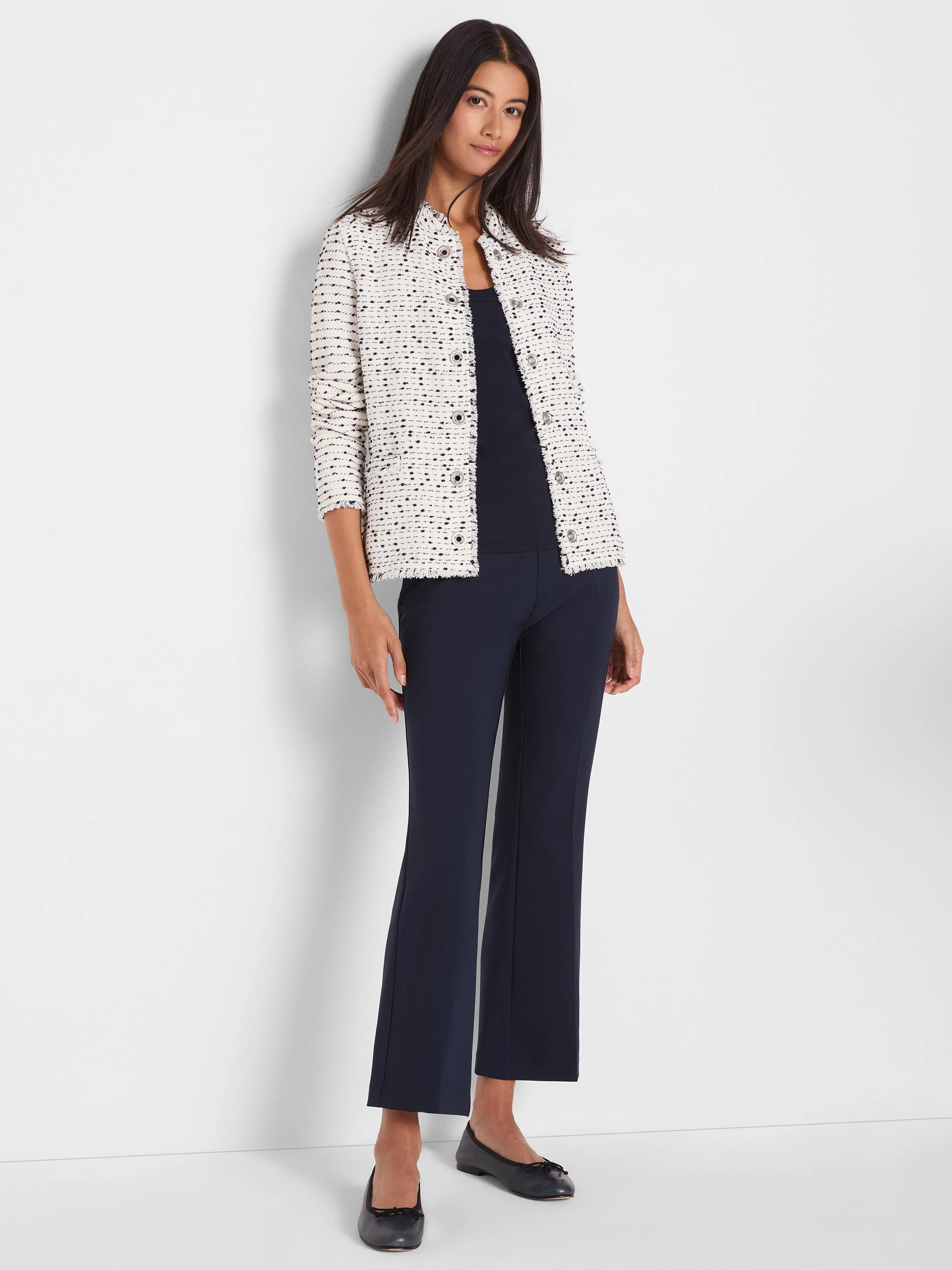 Cream knit jacket with black neps, metal grommets, and frayed edges on collar, placket, and hem.