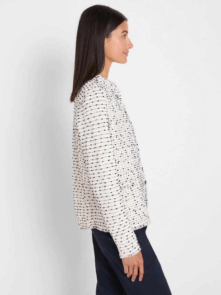 Cream nep weave knit jacket with dark flecks. Features fringed edges, a collarless design, and metal grommet details.