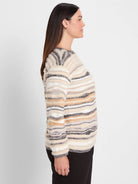 Fuzzy sweater with horizontal stripes in cream, tan, light grey, and dark grey. Long sleeves.