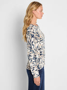 Cream, blue, and tan blurry leaf pattern sweater with long sleeves, shown on a model.