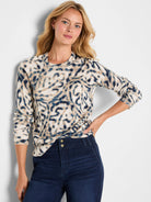 Cream, navy, and tan long-sleeve crew-neck sweater with a blurry, abstract leaf-like pattern.