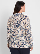 Cream sweater featuring a blurry, organic pattern in dark blue and tan. Model wears it from behind.