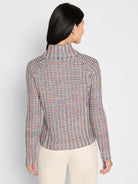 Tuck stitch jacket, seen from behind. Features a repeating pattern in cream, navy, red, and yellow. Long sleeves, mock neck.