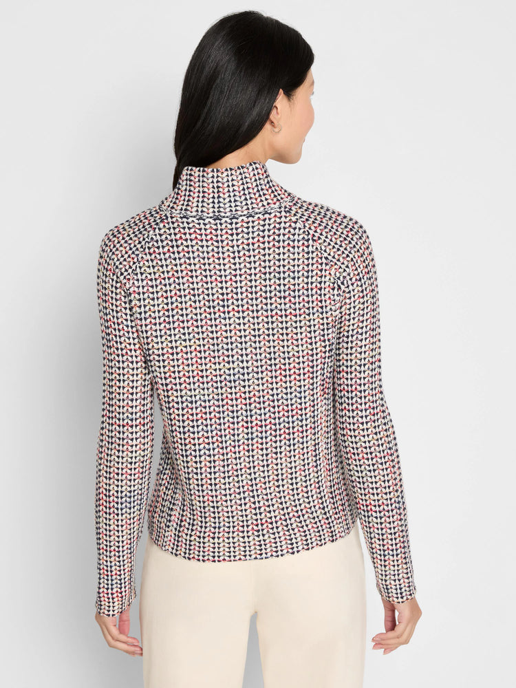 Tuck stitch jacket, seen from behind. Features a repeating pattern in cream, navy, red, and yellow. Long sleeves, mock neck.