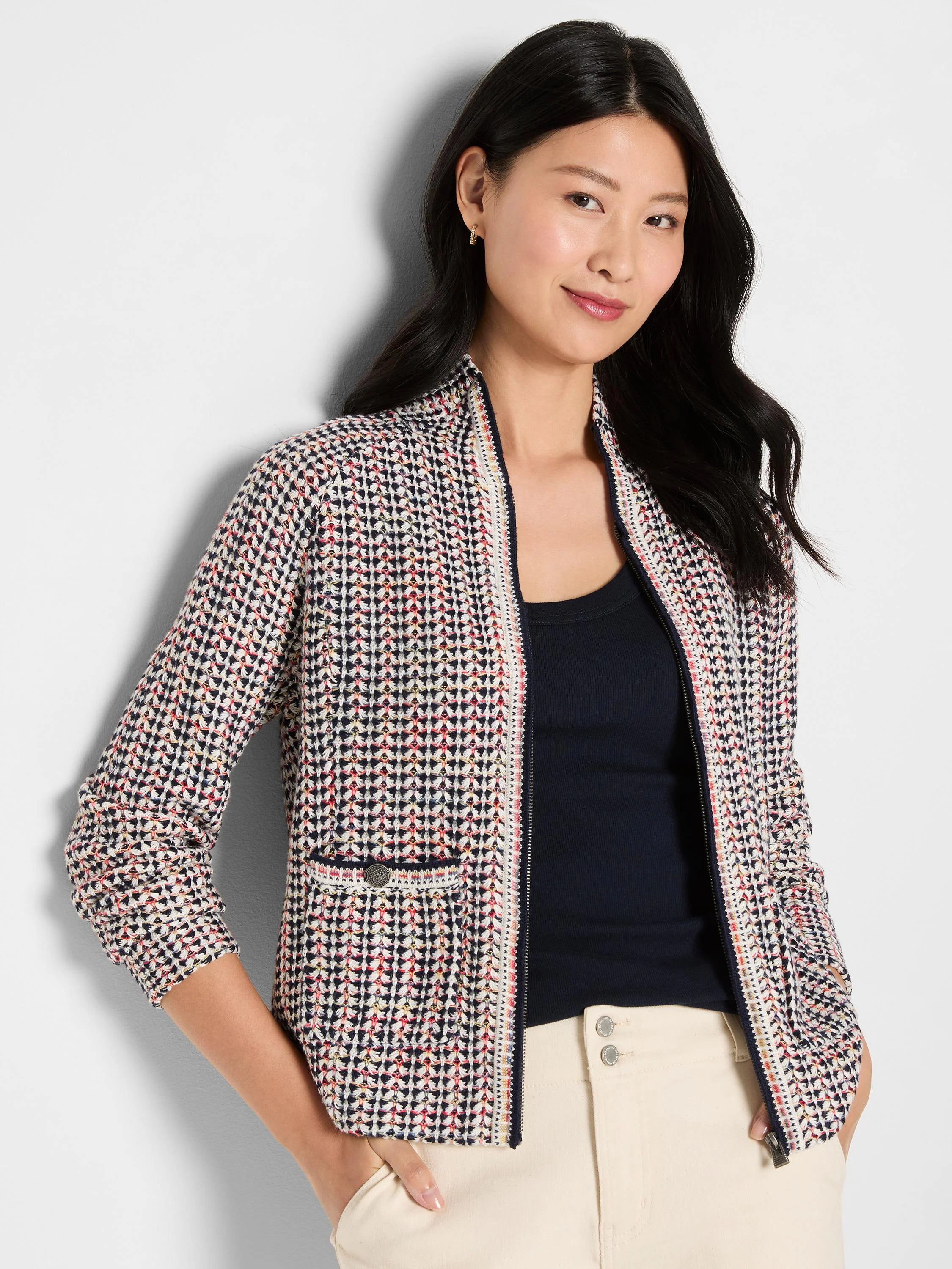 Tuck stitch jacket with navy, cream, red, and yellow woven pattern. Full-zip front and small buttoned pocket.