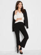 Dark knit jacket with metallic flecks throughout, worn open over a white top.
