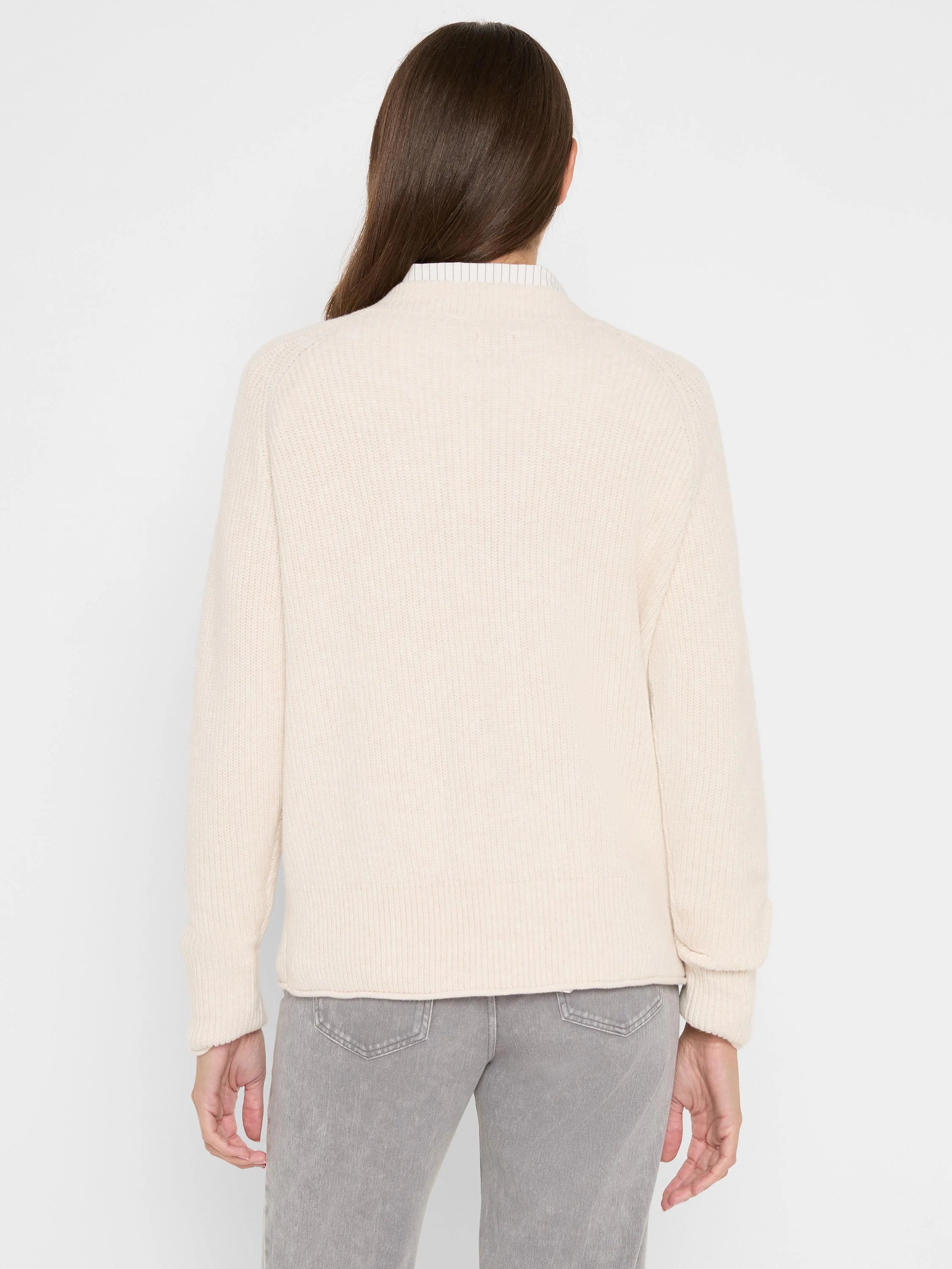 Back view: cream shaker stitch sweater with crew neck, ribbed cuffs & hem. Layered over a striped shirt.