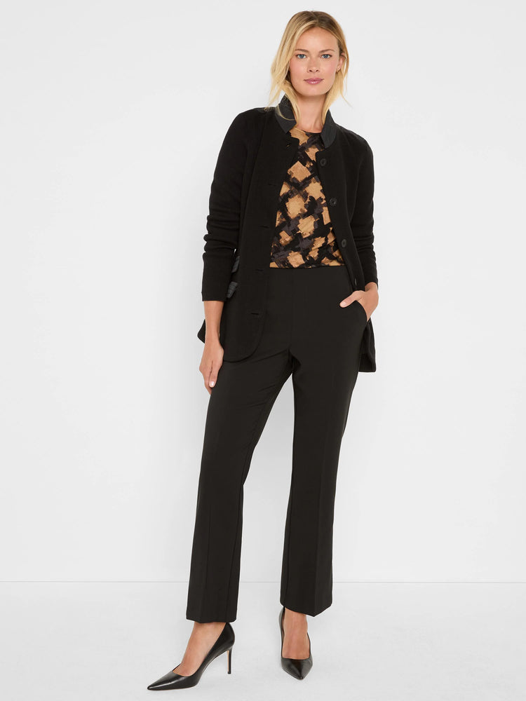 Black, brown, tan abstract check sweater with crew neck, layered under a black cardigan.