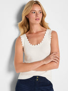 Cream ribbed sweater tank with scallop trim on the neckline and armholes.