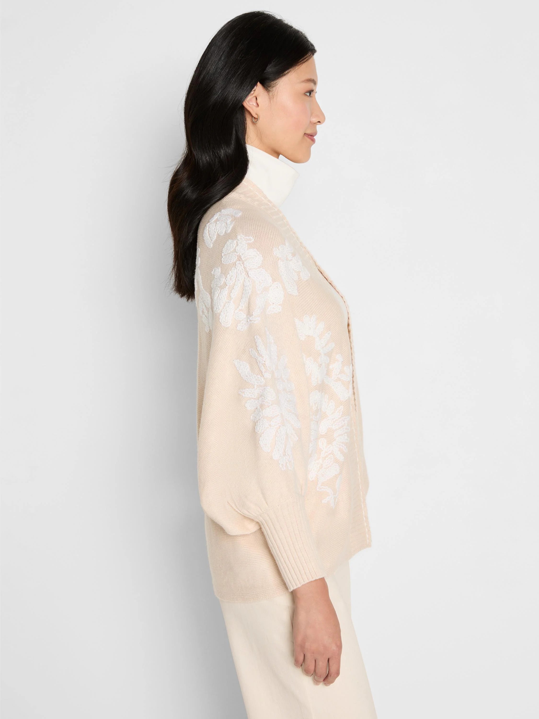 Cream open cardigan with raised white floral embroidery on sleeves and front.
