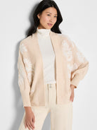 Light beige open cardigan with raised white floral embroidery covering the front and sleeves.