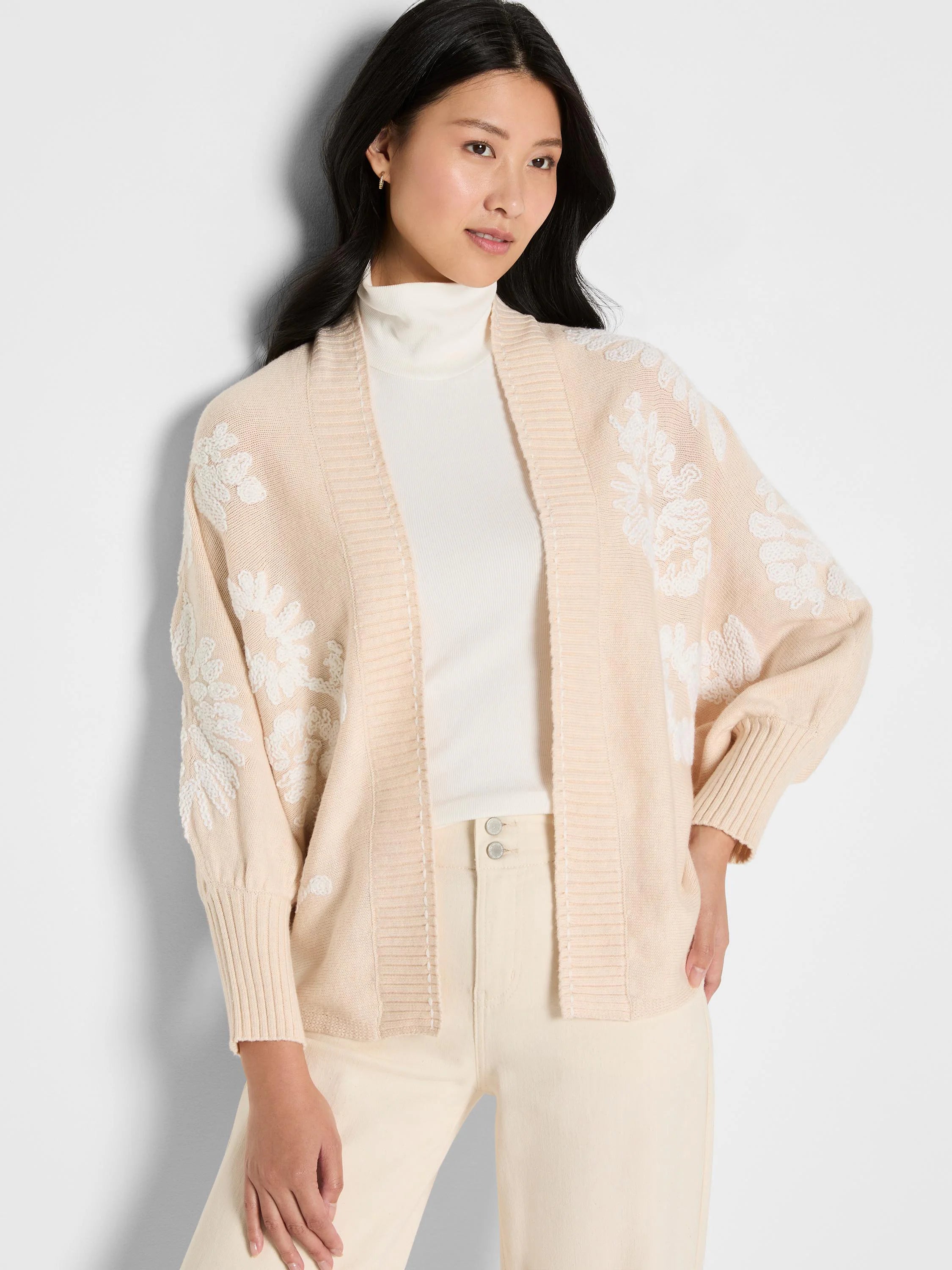 Light beige open cardigan with raised white floral embroidery covering the front and sleeves.