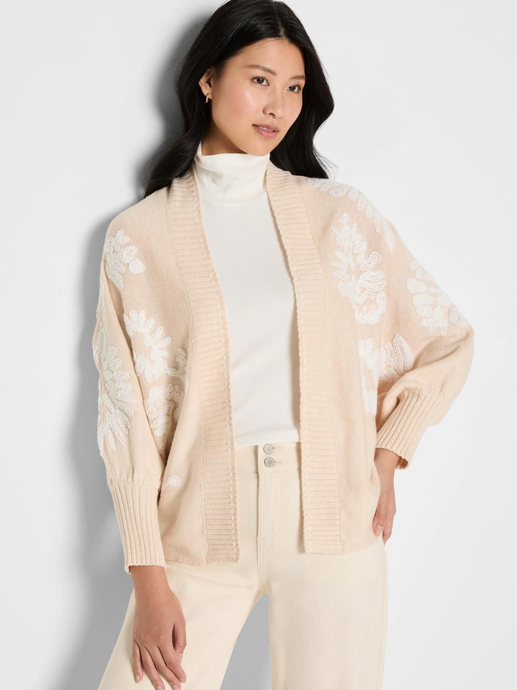 Light beige open cardigan with raised white floral embroidery covering the front and sleeves.